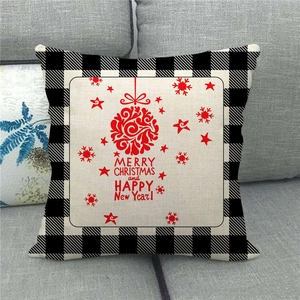 Detail of linen Christmas cushion cover featuring buffalo plaid edges and festive red print