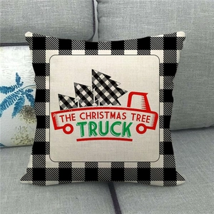 Detailed texture of linen pillowcase with red Christmas truck and buffalo plaid border