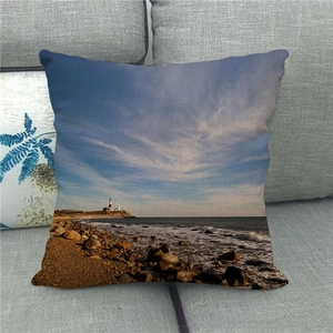 Housse de coussin en lin avec motif de phare côtier sur un canapé en tissu gris