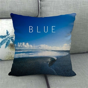 Détail de la housse de coussin en lin avec motif vagues de mer et texte BLUE sur le tissu