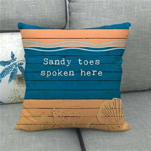 Détail de housse de coussin en lin thème plage avec texte Sandy Toes et coquillages