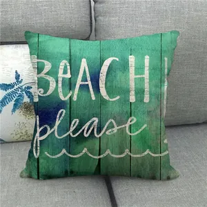 Vue détaillée d'une housse de coussin en lin avec texte BEACH please sur un canapé