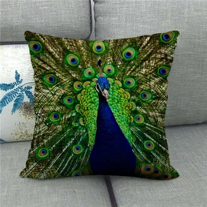 Housse de coussin en lin avec motif de paon coloré posée sur un canapé gris moderne