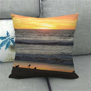Gros plan d'une housse de coussin en lin avec vagues de coucher de soleil sur canapé