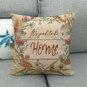 Detail view of Happy Fall linen pillow case with wreath design and home quote on sofa