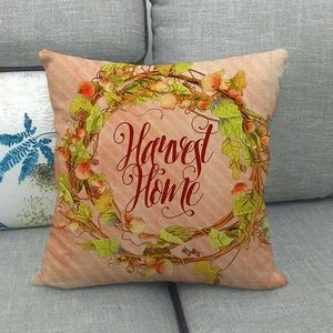 Close-up of Harvest Home autumn wreath linen pillowcase on a cozy grey sofa
