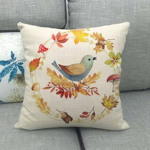 Close-up of linen pillowcase featuring fall wreath with bird and maple leaf details