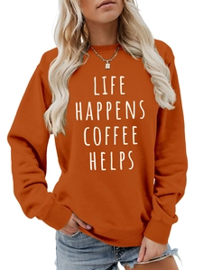 Detail of white Life Happens Coffee Helps text on caramel orange crewneck sweatshirt