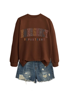 Flat lay of brown pullover sweatshirt with emergency department print and ripped denim shorts