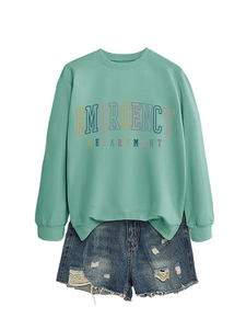Flat lay of mint green sweatshirt with retro blue distressed denim shorts set