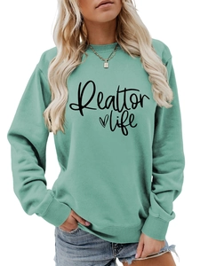 Detail of mint green sweatshirt with Realtor Life print and heart icon on soft fabric
