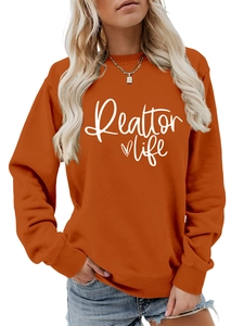 Detail of pumpkin orange Realtor life sweatshirt showing white print and cotton texture
