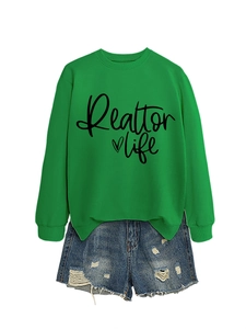 Detail of green Realtor Life sweatshirt with heart print and distressed denim shorts