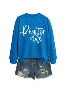 Detail of Realtor Life print on blue sweatshirt paired with ripped denim shorts