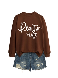 Flat lay of brown Realtor Life sweatshirt paired with distressed blue denim shorts