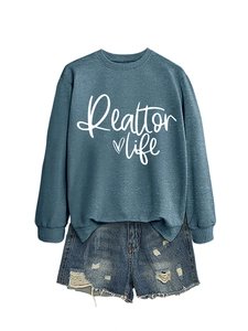 Flat lay of a grey Realtor Life sweatshirt paired with distressed denim shorts