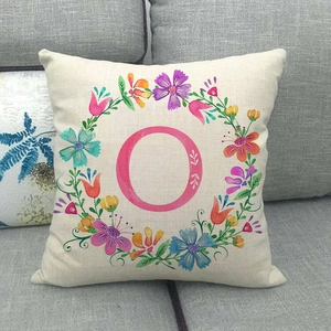 Federa in lino con ghirlanda floreale e lettera O rosa stampata su cuscino beige