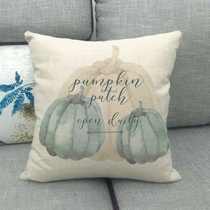 Detail of linen pillow cover featuring watercolor pumpkin graphics and festive text