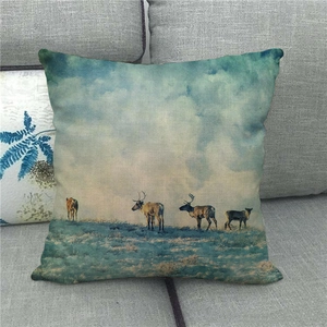 Détail d'une housse de coussin en lin avec imprimé renne sur un canapé gris