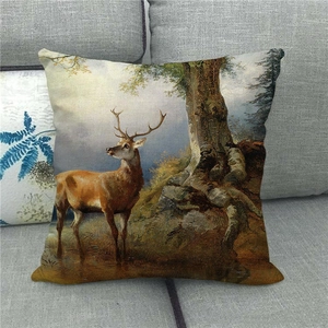 Housse de coussin en lin avec motif cerf de forêt sur un canapé gris pour décoration