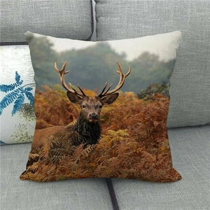 Housse de coussin en lin avec portrait de cerf sur un canapé en tissu gris moderne