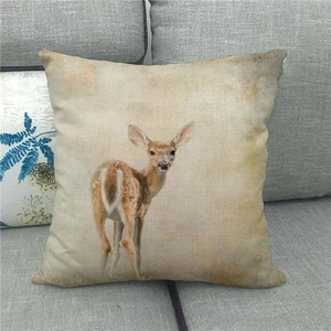 Détail de la housse de coussin en lin avec motif élan sur un canapé gris moderne