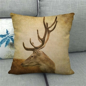 Gros plan du motif cerf vintage sur taie d'oreiller en lin sur un canapé gris