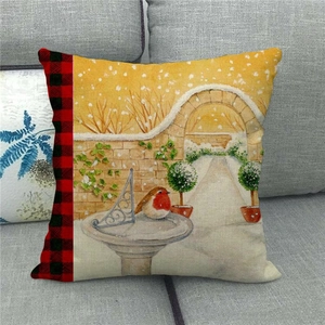 Detail of linen pillow cover featuring winter bird illustration and buffalo plaid edge
