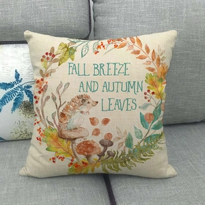 Macro shot of linen pillow case featuring autumn leaves and fall breeze typography