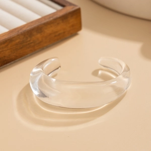 Macro shot of clear acrylic chunky C-shaped bracelet with minimalist geometric design