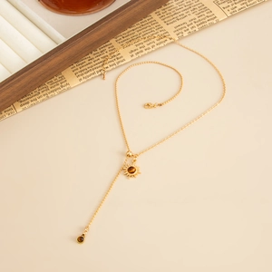 Detailed view of a golden Y-shaped lariat necklace with a tiger stone sun pendant