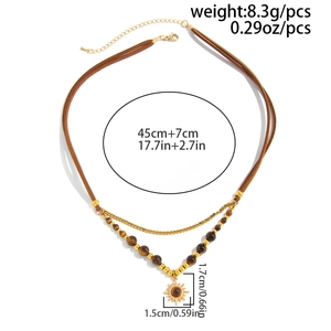 Detail of vintage layered necklace featuring tiger eye beads and sun totem pendant