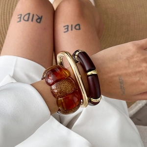 Three-piece stackable vintage resin and gold alloy bangles for women on model wrist