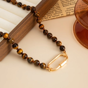 Tiger eye beaded necklace with a golden oval screw clasp in a vintage style aesthetic