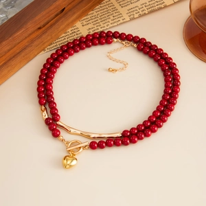 Double-layered red acrylic beaded necklace with heart pendant and gold metal toggle clasp