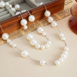 Detail van elegante lange ketting met witte faux parels op een zilverkleurige ketting