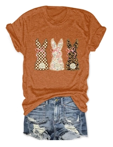 Close-up of orange t-shirt with bunny silhouettes and distressed denim shorts