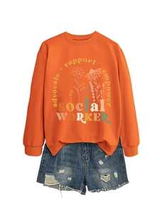 Flat lay of an orange sweatshirt with floral advocate print and ripped denim shorts