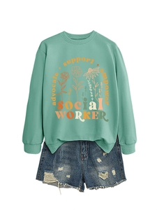 Detail of light green sweatshirt featuring orange floral print and empowerment text