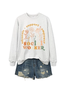 Flat lay of gray Social Worker sweatshirt with floral print and frayed denim shorts