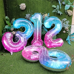 Detalle de globos de números metálicos en degradado con patrones de estrellas blancas