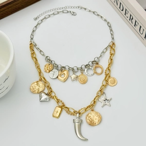 Detail of layered gold and silver mixed pendant necklace with heart and star charms