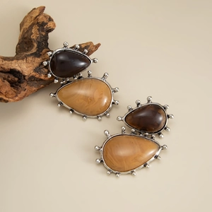 Detail of vintage teardrop earrings featuring amber resin stones with silver beaded edges
