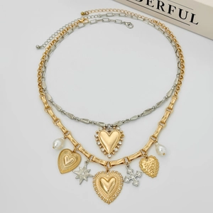 Detail of layered mixed-metal necklace with heart charms, stars and faux pearls