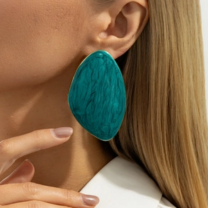 Detailed view of French vintage oversized earrings with turquoise marble texture and gold edges