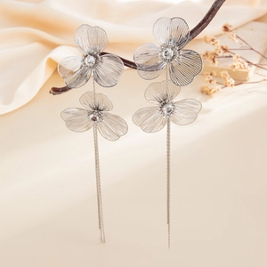 Detailed close-up of double-layered silver ginkgo leaf earrings with tassels on silk