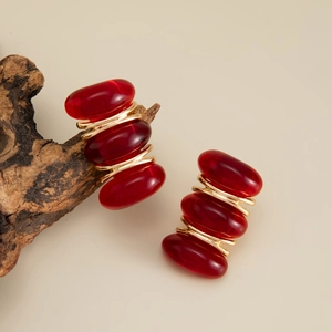 Detailed view of vintage geometric resin earrings with gold wire wrap on rustic wood