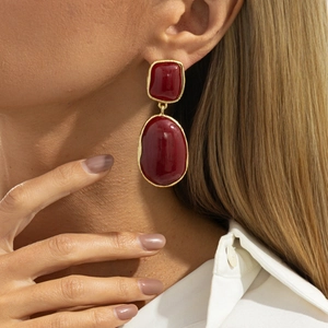 Close-up of vintage red gemstone drop earrings with elegant gold-rimmed irregular design