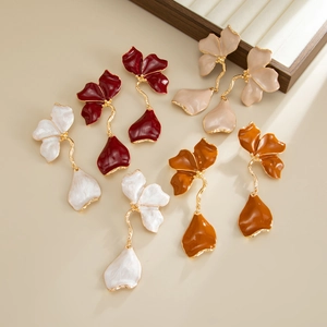 Detailed view of 3D metal flower petal drop earrings in burgundy and beige colors