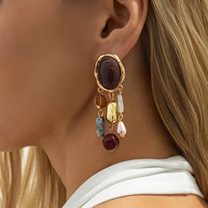 Macro shot of French retro earrings with colorful gemstones and tassel charms on a model